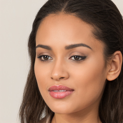 Joyful latino young-adult female with long  brown hair and brown eyes