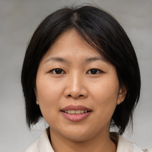 Joyful asian adult female with medium  brown hair and brown eyes