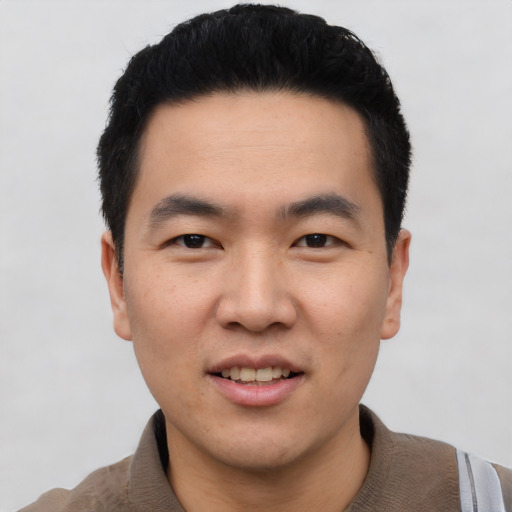 Joyful asian young-adult male with short  black hair and brown eyes