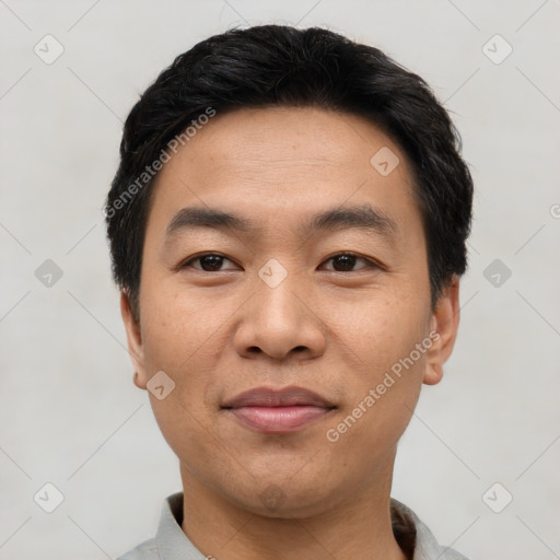 Joyful asian young-adult male with short  black hair and brown eyes