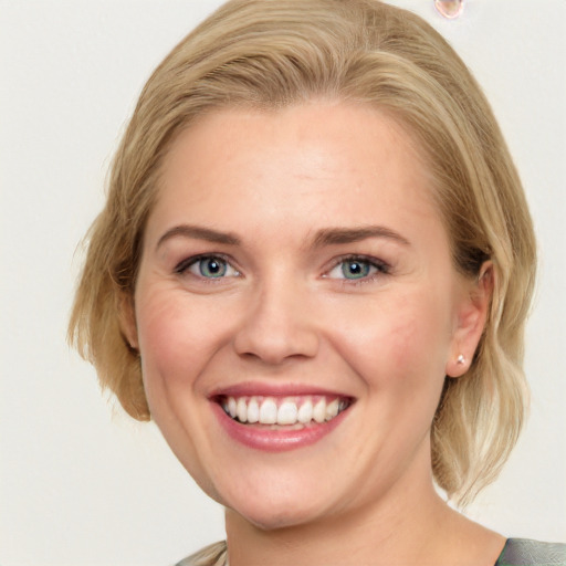 Joyful white young-adult female with medium  brown hair and blue eyes