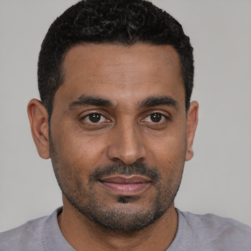 Joyful black young-adult male with short  brown hair and brown eyes
