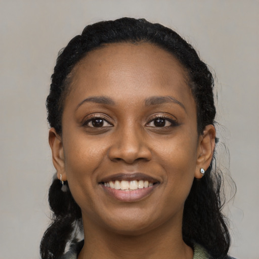 Joyful black young-adult female with long  black hair and brown eyes