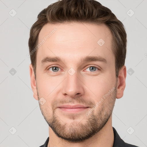 Joyful white young-adult male with short  brown hair and grey eyes