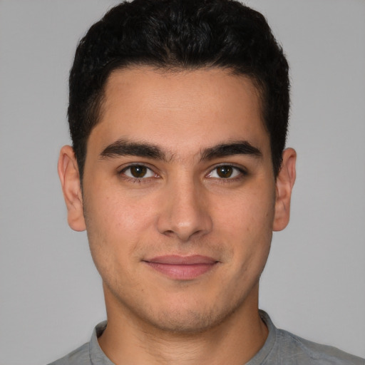 Joyful latino young-adult male with short  brown hair and brown eyes