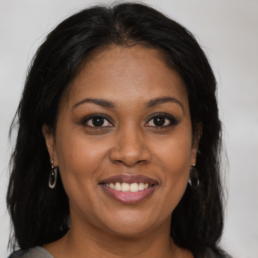 Joyful black young-adult female with long  brown hair and brown eyes