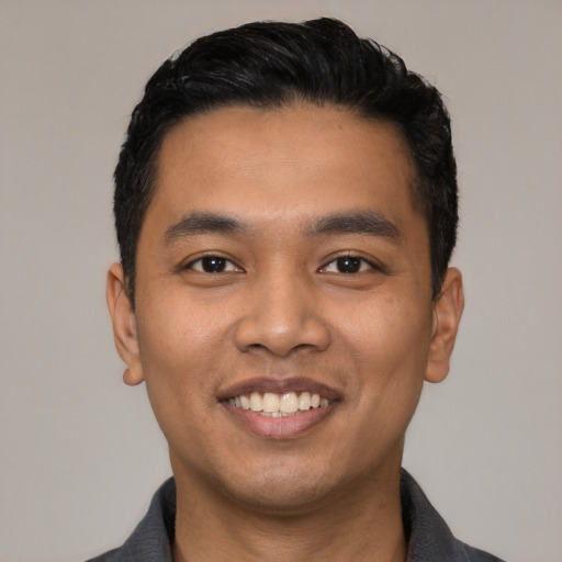 Joyful latino young-adult male with short  black hair and brown eyes