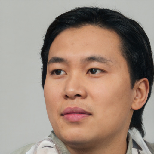 Joyful asian young-adult male with medium  black hair and brown eyes