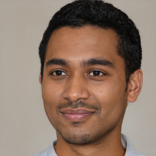 Joyful black young-adult male with short  black hair and brown eyes