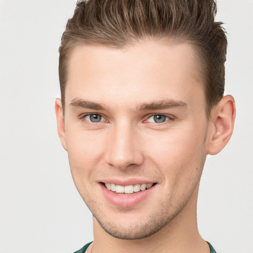 Joyful white young-adult male with short  brown hair and grey eyes