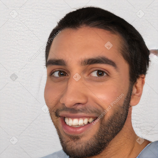 Joyful white young-adult male with short  black hair and brown eyes