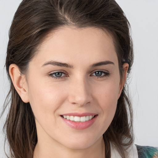 Joyful white young-adult female with medium  brown hair and grey eyes