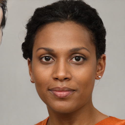 Joyful black young-adult female with short  brown hair and brown eyes