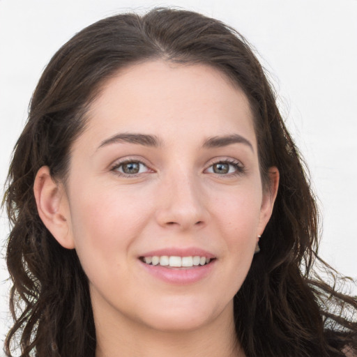 Joyful white young-adult female with long  brown hair and grey eyes