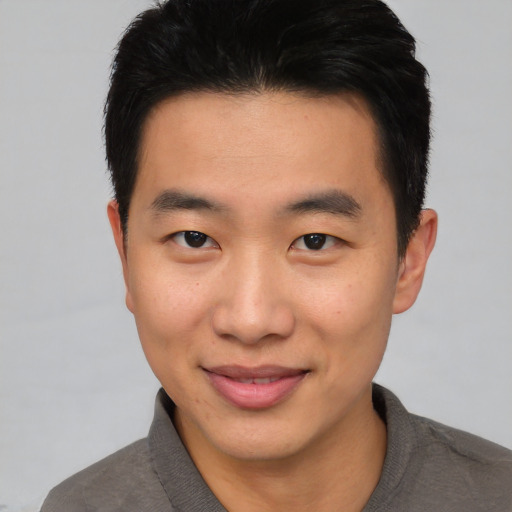 Joyful asian young-adult male with short  brown hair and brown eyes