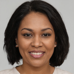 Joyful black adult female with medium  brown hair and brown eyes