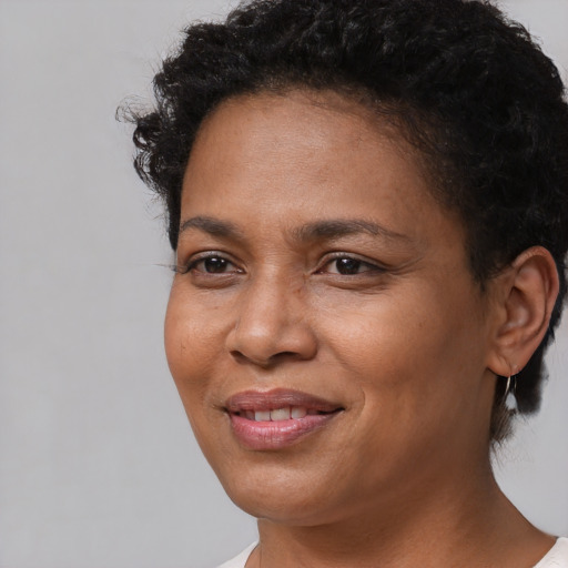 Joyful black adult female with short  black hair and brown eyes