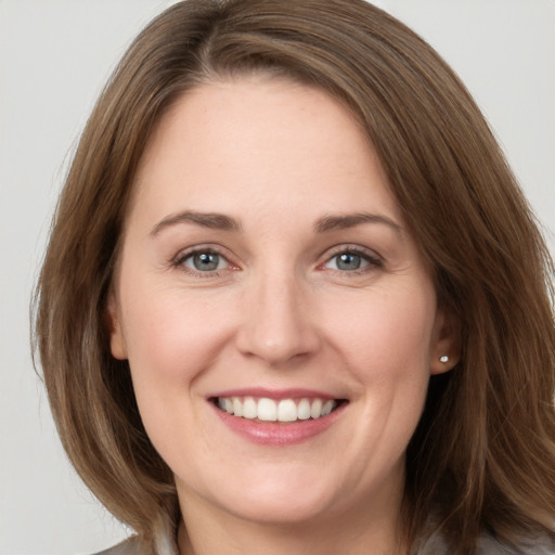 Joyful white young-adult female with medium  brown hair and grey eyes