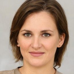 Joyful white young-adult female with medium  brown hair and green eyes