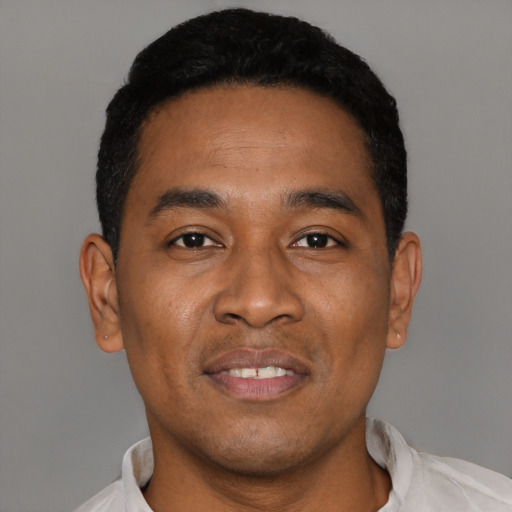 Joyful black young-adult male with short  black hair and brown eyes