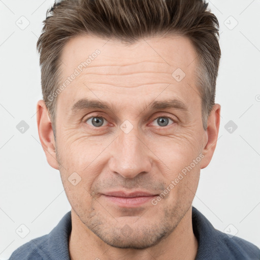 Joyful white adult male with short  brown hair and grey eyes