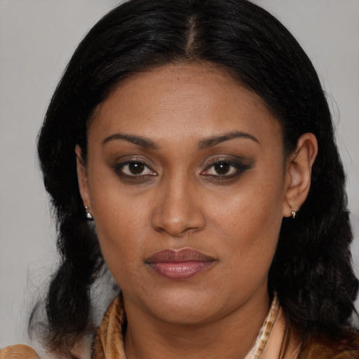 Joyful black young-adult female with long  brown hair and brown eyes