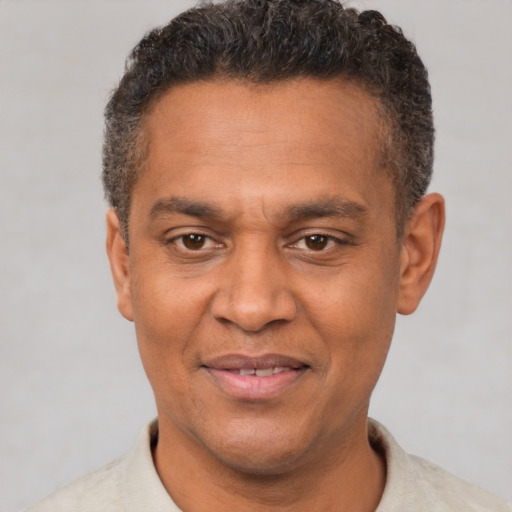 Joyful black adult male with short  brown hair and brown eyes