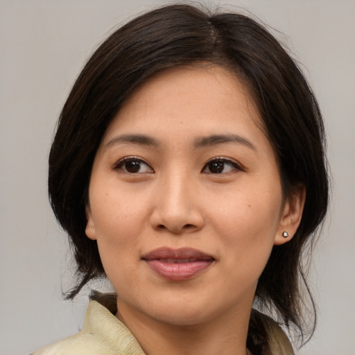 Joyful asian young-adult female with medium  brown hair and brown eyes