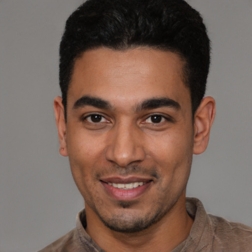 Joyful latino young-adult male with short  black hair and brown eyes