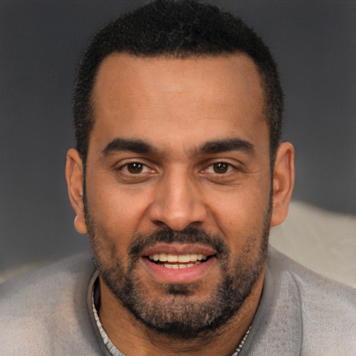 Joyful black young-adult male with short  black hair and brown eyes