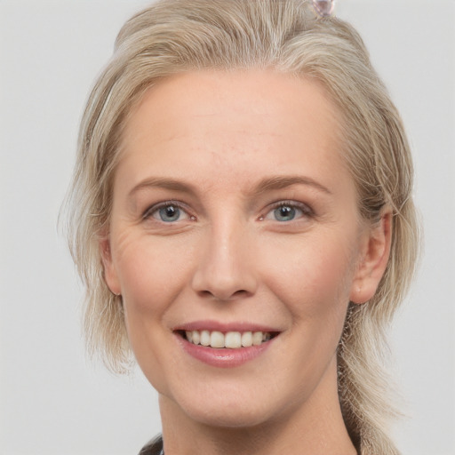 Joyful white young-adult female with long  blond hair and grey eyes