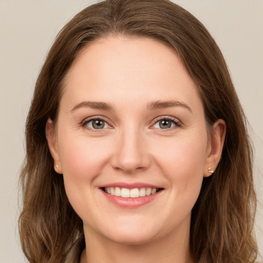 Joyful white young-adult female with long  brown hair and grey eyes