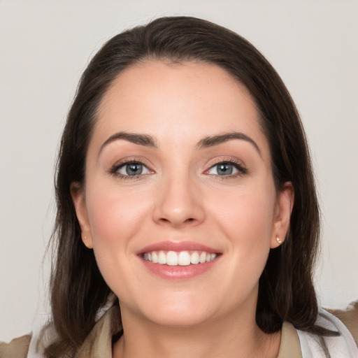 Joyful white young-adult female with medium  brown hair and grey eyes