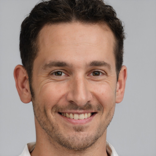 Joyful white adult male with short  brown hair and brown eyes