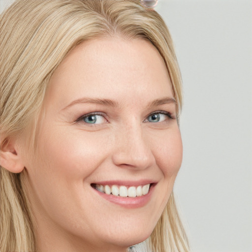 Joyful white young-adult female with long  blond hair and blue eyes