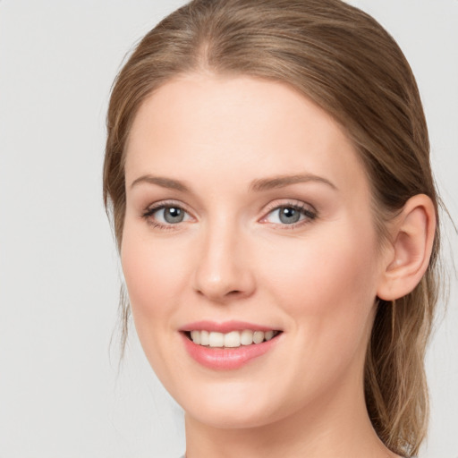 Joyful white young-adult female with long  brown hair and blue eyes