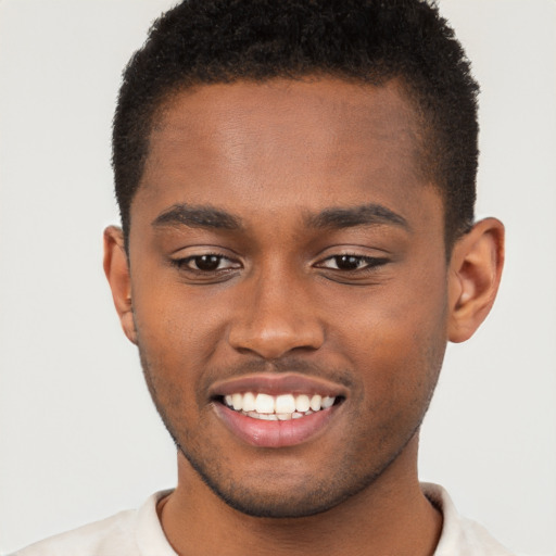 Joyful black young-adult male with short  brown hair and brown eyes