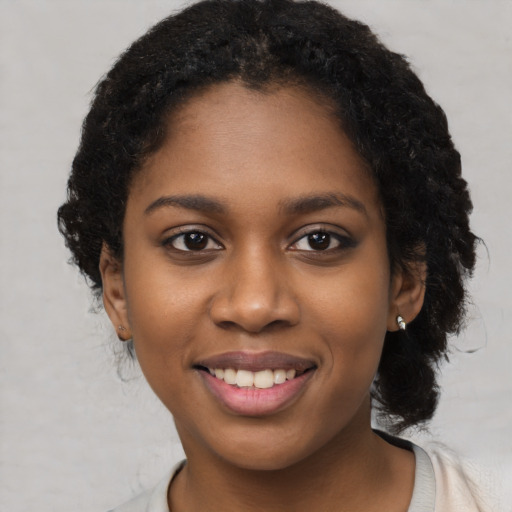 Joyful black young-adult female with short  black hair and brown eyes