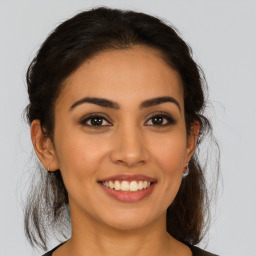 Joyful latino young-adult female with medium  brown hair and brown eyes