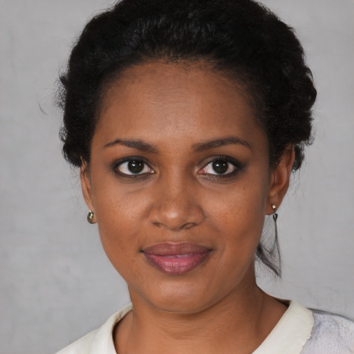 Joyful black young-adult female with short  black hair and brown eyes