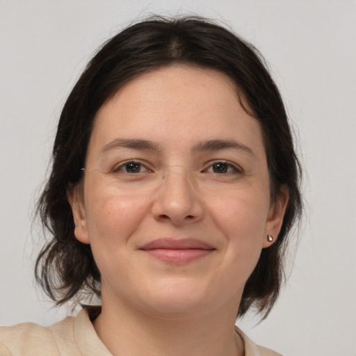 Joyful white young-adult female with medium  brown hair and brown eyes