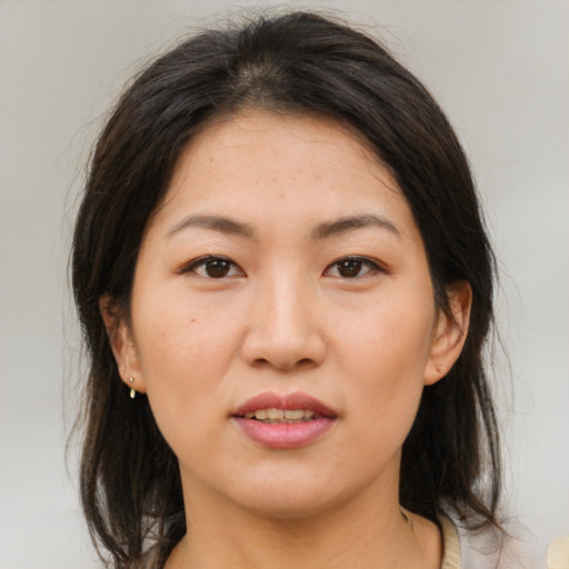 Joyful asian young-adult female with medium  brown hair and brown eyes