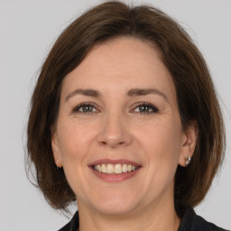 Joyful white adult female with medium  brown hair and grey eyes