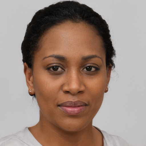 Joyful black young-adult female with short  black hair and brown eyes