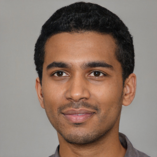 Joyful black young-adult male with short  black hair and brown eyes