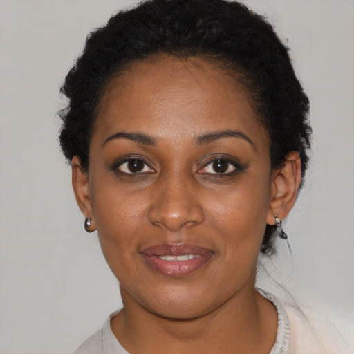 Joyful black young-adult female with short  black hair and brown eyes