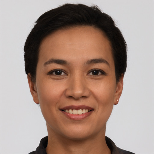 Joyful latino young-adult female with short  black hair and brown eyes