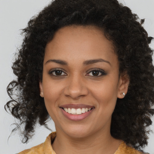 Joyful black young-adult female with medium  brown hair and brown eyes