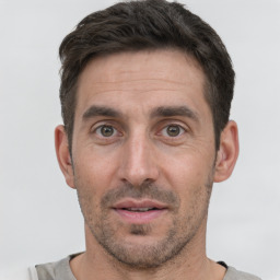 Joyful white adult male with short  black hair and brown eyes