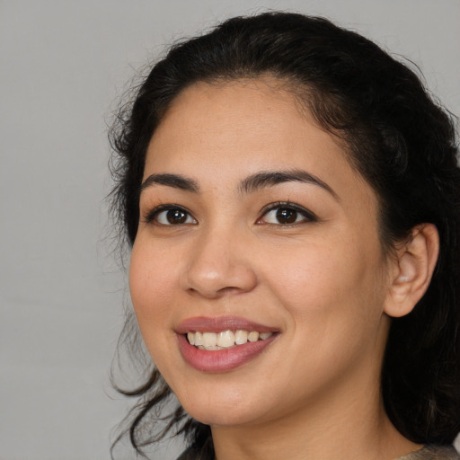 Joyful latino young-adult female with medium  brown hair and brown eyes